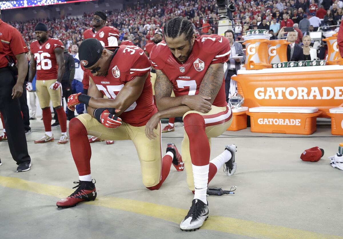 San Francisco 49ers safety Eric Reid (35) and quarterback Colin Kaepernick (7) kneel during the national anthem before a game against the Rams in Santa Clara.