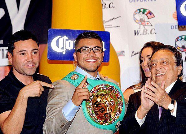 Oscar De La Hoya poses with Golden Boy Promotions boxer Victor Ortiz and WBC President Jose Suleiman during a news conference in Mexico City after Ortiz defeated Andre Berto for the WBC welterweight title.