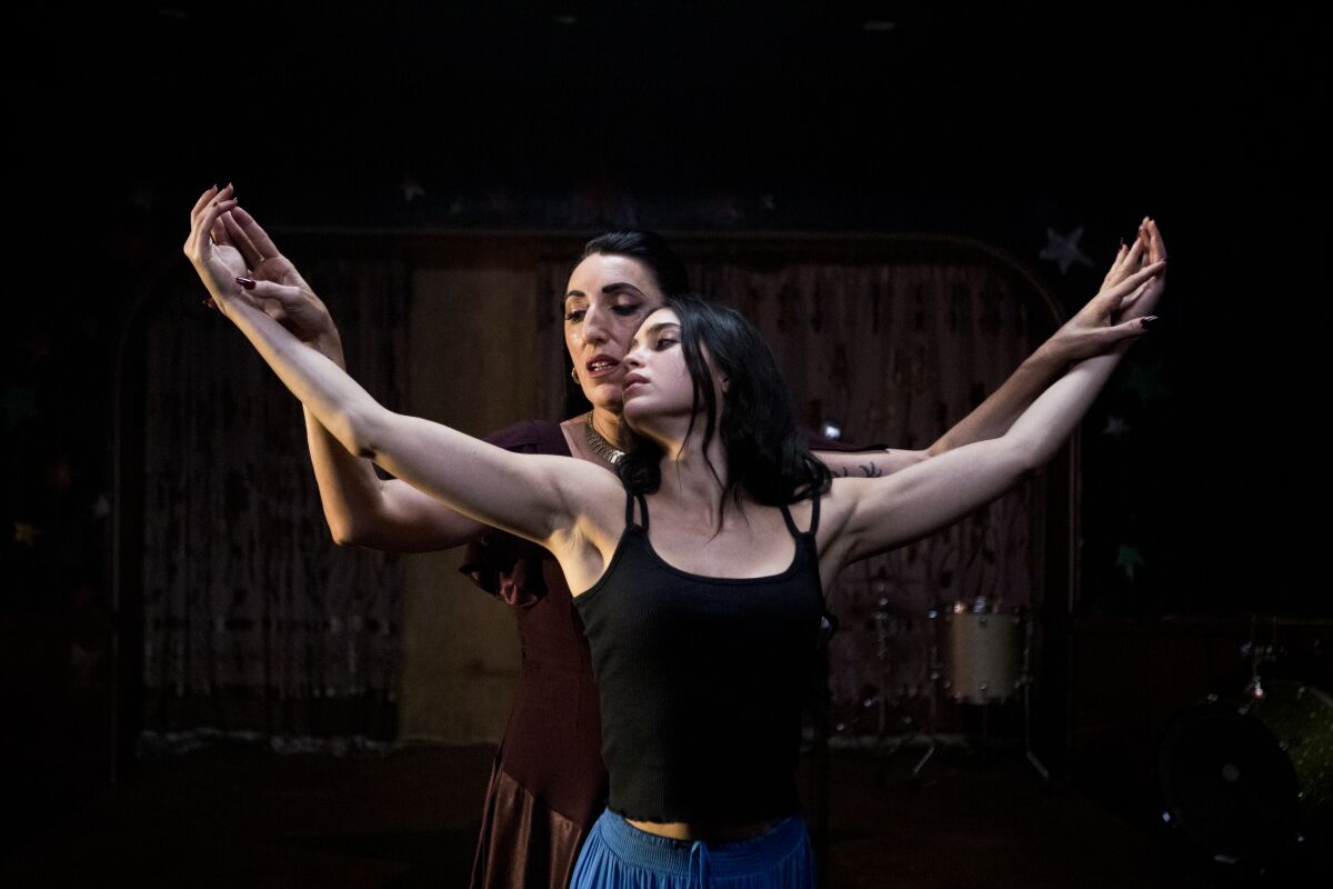 A still from "Carmen" shows Rossy de Palma gently stroking Melissa Barrera's extended arms in a dancerly pose.