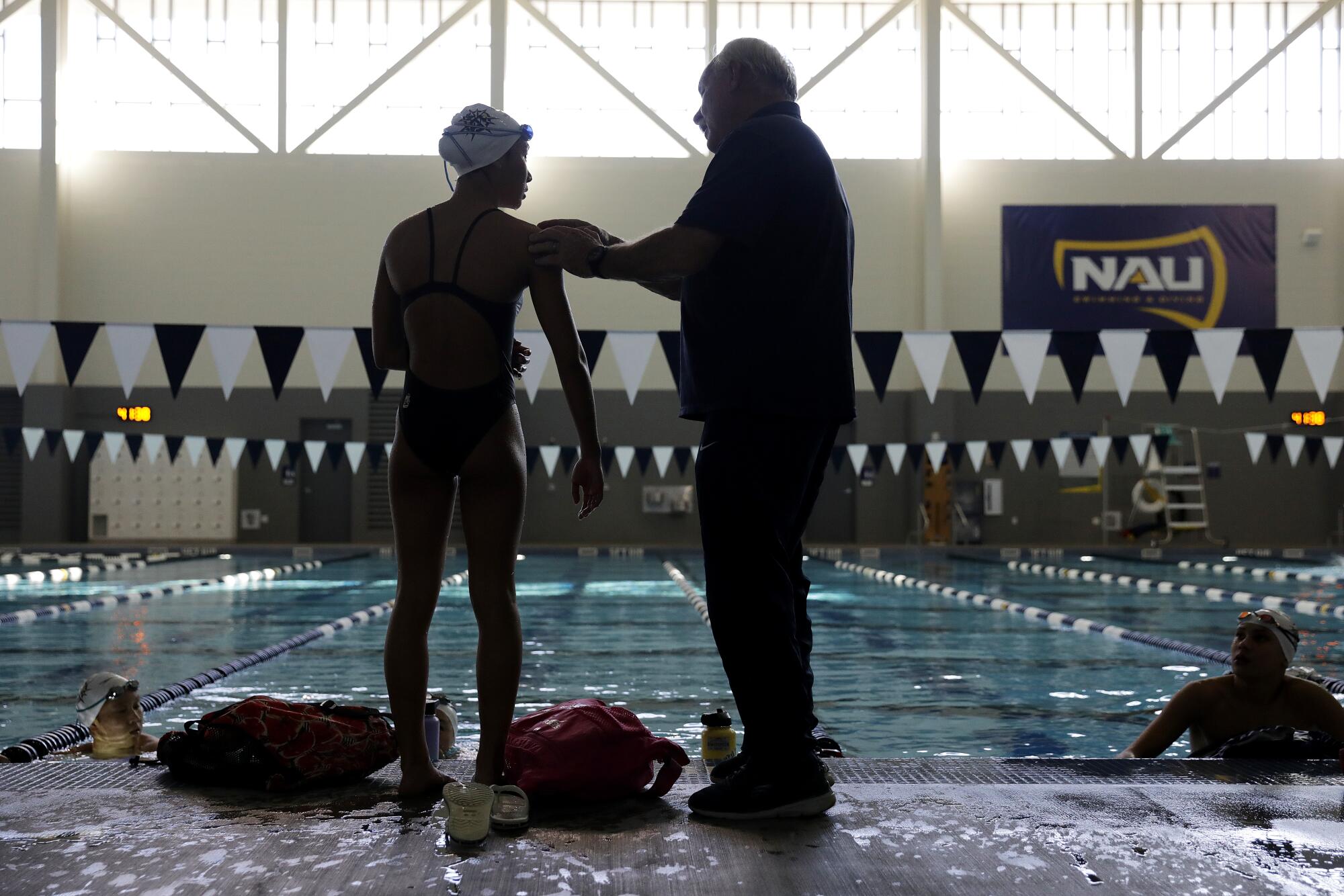 Coach Rick Shipherd checks in with Clemence Choy while they stand poolside.