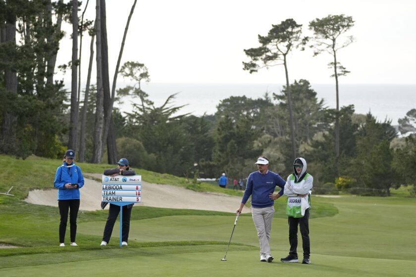 Hank Lebioda, second from right, waits to putt on the 18th green of the Monterey Peninsula Country Club Shore Course during the first round of the AT&T Pebble Beach Pro-Am golf tournament in Pebble Beach, Calif., Thursday, Feb. 2, 2023. (AP Photo/Eric Risberg)