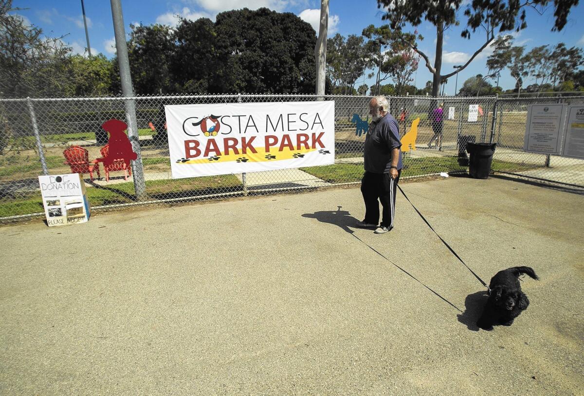 A man walks his dog at the Bark Park in Costa Mesa in 2015. Exploring development of another local dog park is among the recommendations in a proposed update to the city’s Open Space Master Plan of Parks and Recreation.