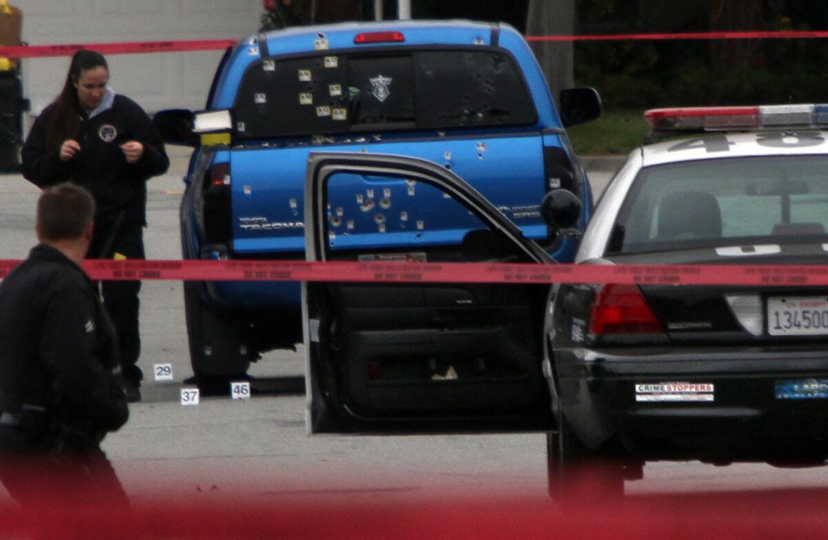 Crime scene tape surrounds a pickup truck in which two women were shot by L.A. police while delivering newspapers.