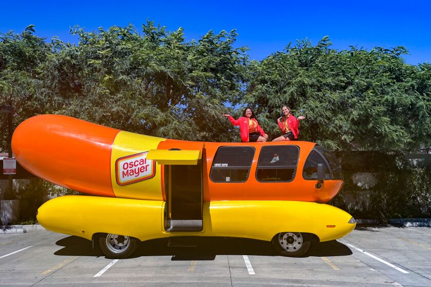 Hotdoggers Keila Garza and Abbey Rank sit atop the Oscar Mayer Wienermobile.