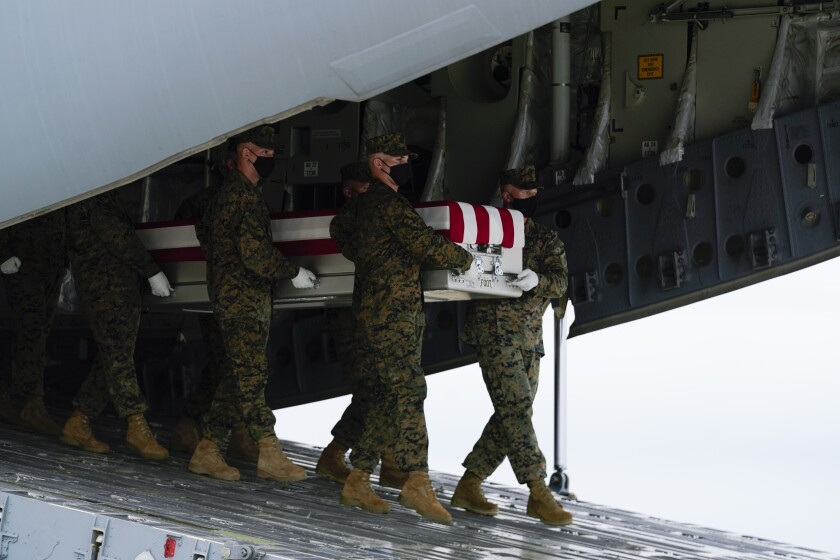 تفنگداران دریایی بقایای پوشیده از پرچم را حمل می کنند.