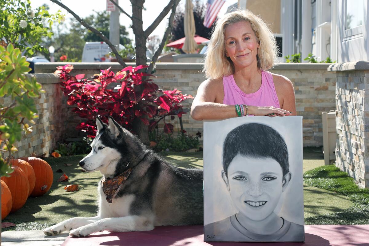 Newport Beach resident Amy Von Der Ahe poses with a portrait of her son Johnny and his dog Koda, a 5-year-old Husky. 