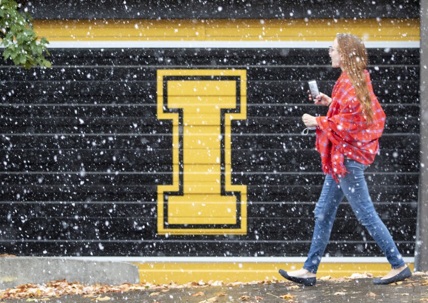 FILE - A woman walks across the University of Idaho campus during a snowstorm of the season on Oct. 23, 2020, in Moscow, Idaho. Political hostility to public education in the Republican-dominated Idaho Legislature is causing some businesses to doubt the wisdom of moving to or expanding in the state. (Geoff Crimmins/The Moscow-Pullman Daily News via AP, File)