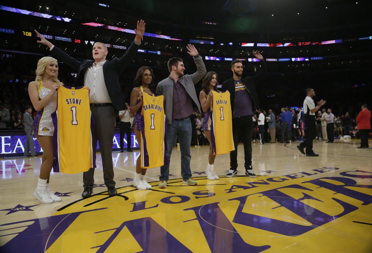 The Laker Girls present jerseys to Spencer Stone, Alek Skarlatos and Anthony Sadler during a game against the Pistons. The three American men foiled a terrorist attack on a Paris-bound train in August.