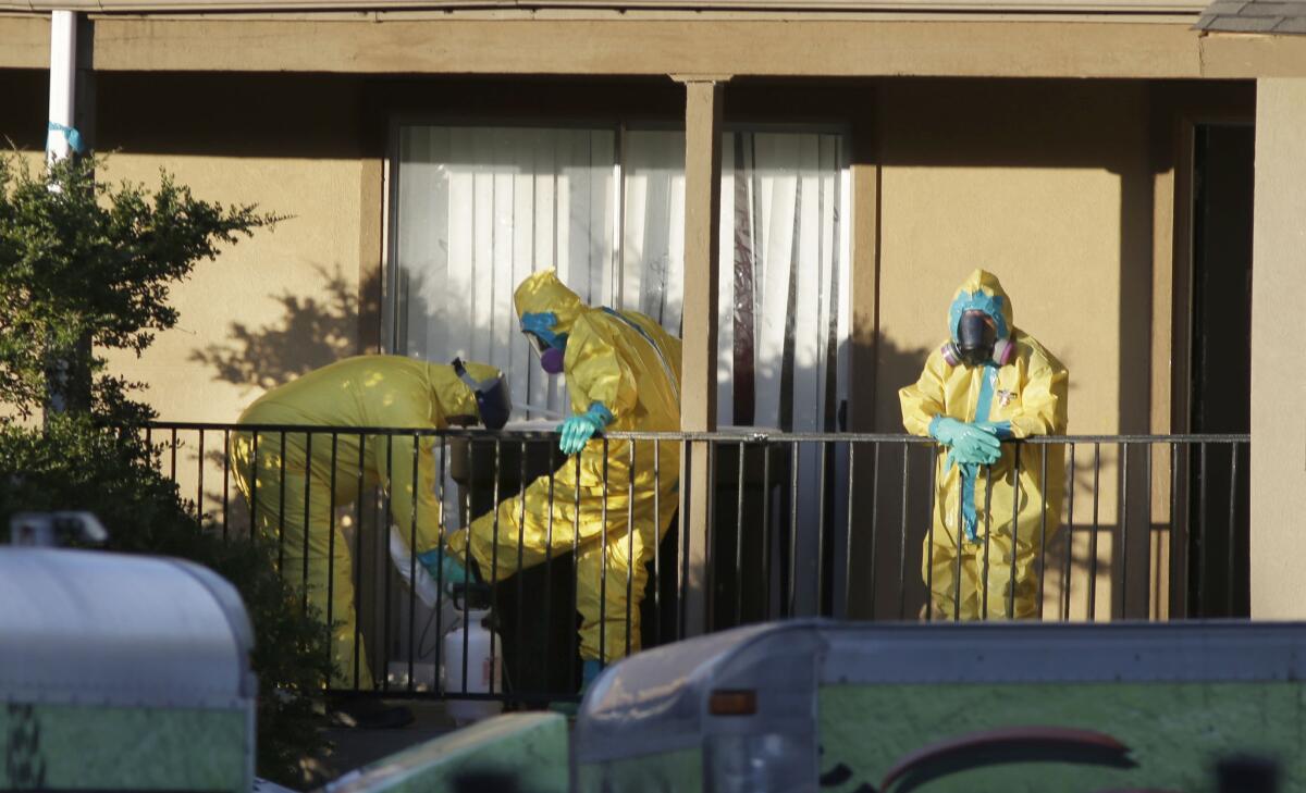 Cleaners disinfect their protective gear last week after working in the Dallas apartment where Thomas Eric Duncan stayed before being diagnosed with Ebola. He died Wednesday.