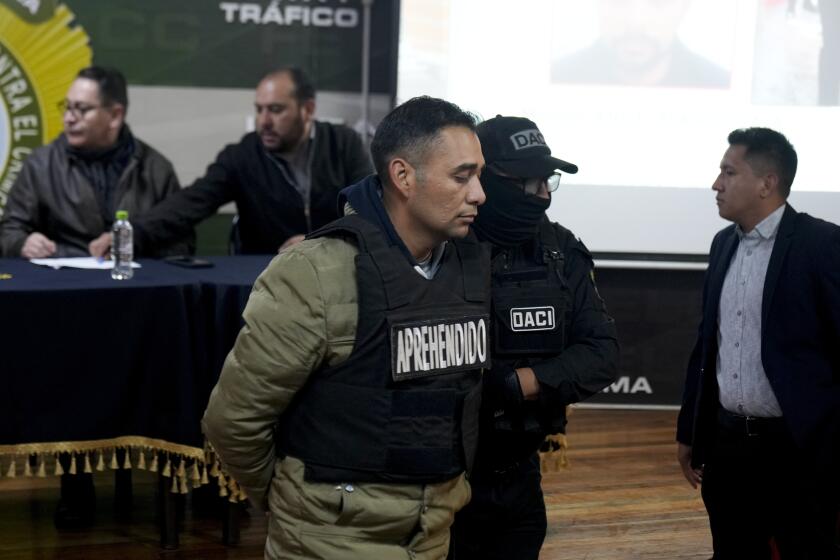 Miguel Ángel Burgos es presentado a la prensa esposado por la policía después de su arresto en La Paz, Bolivia, el viernes 28 de junio de 2024. (AP Foto/Juan Karita)