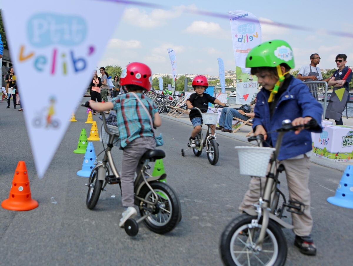 Children ride free bicycles Wednesday during the rollout of the P'tit Velib' bike-sharing program for kids.