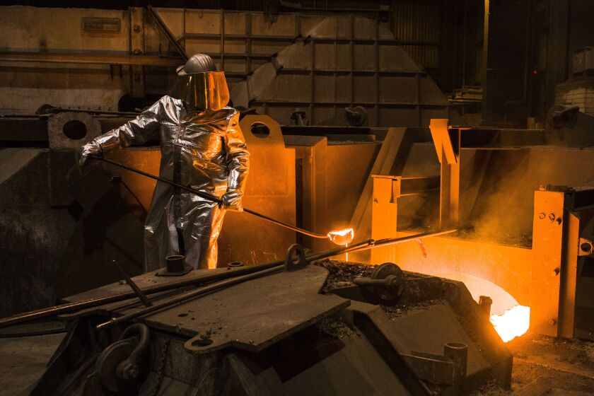 FILE -- An employee in protective clothing takes a sample from the furnace at the steel producer, Salzgitter AG, in Salzgitter, Germany, Thursday, March 22, 2018. Germany’s biggest industrial union has agreed with employers on a pay deal that will see millions of workers get raises totaling 8.5% over two years as well as one-time payments meant to cushion the effect of sky-high inflation. (AP Photo/Markus Schreiber,file)