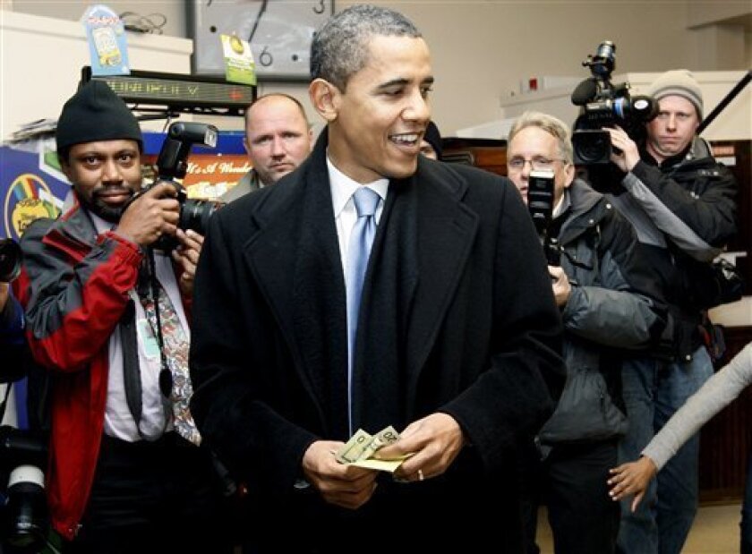 President-elect Barack Obama, with money in hand, looks to pay for his order during a visit to Manny's Deli in Chicago, Friday, Nov. 21, 2008. (AP Photo/Charles Dharapak)