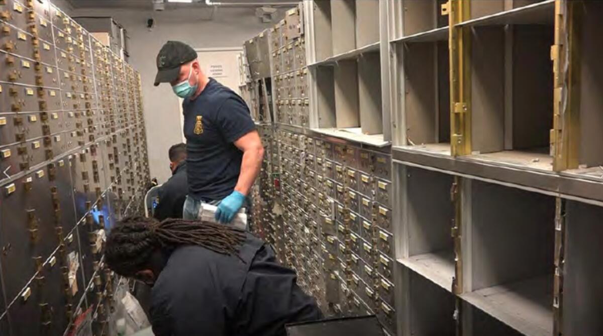 Federal agents, shown in a video screen capture, target safe deposit boxes in a raid.