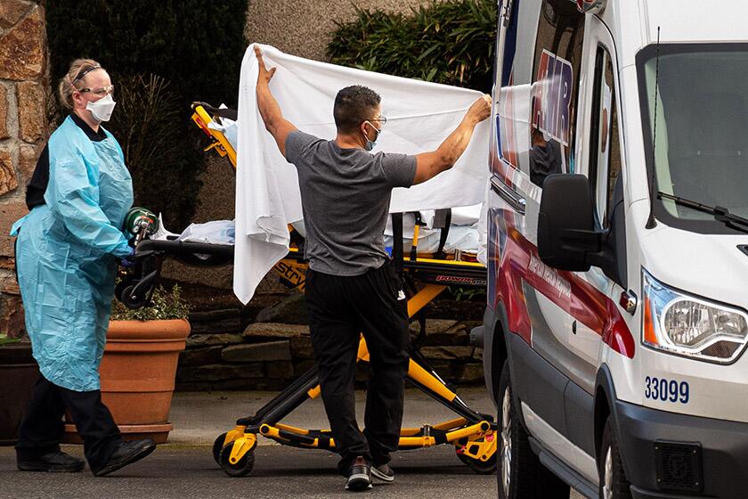 Healthcare workers load a patient into an ambulance at Life Care Center in Kirkland, Wash. Six people in the state have died from the coronavirus.