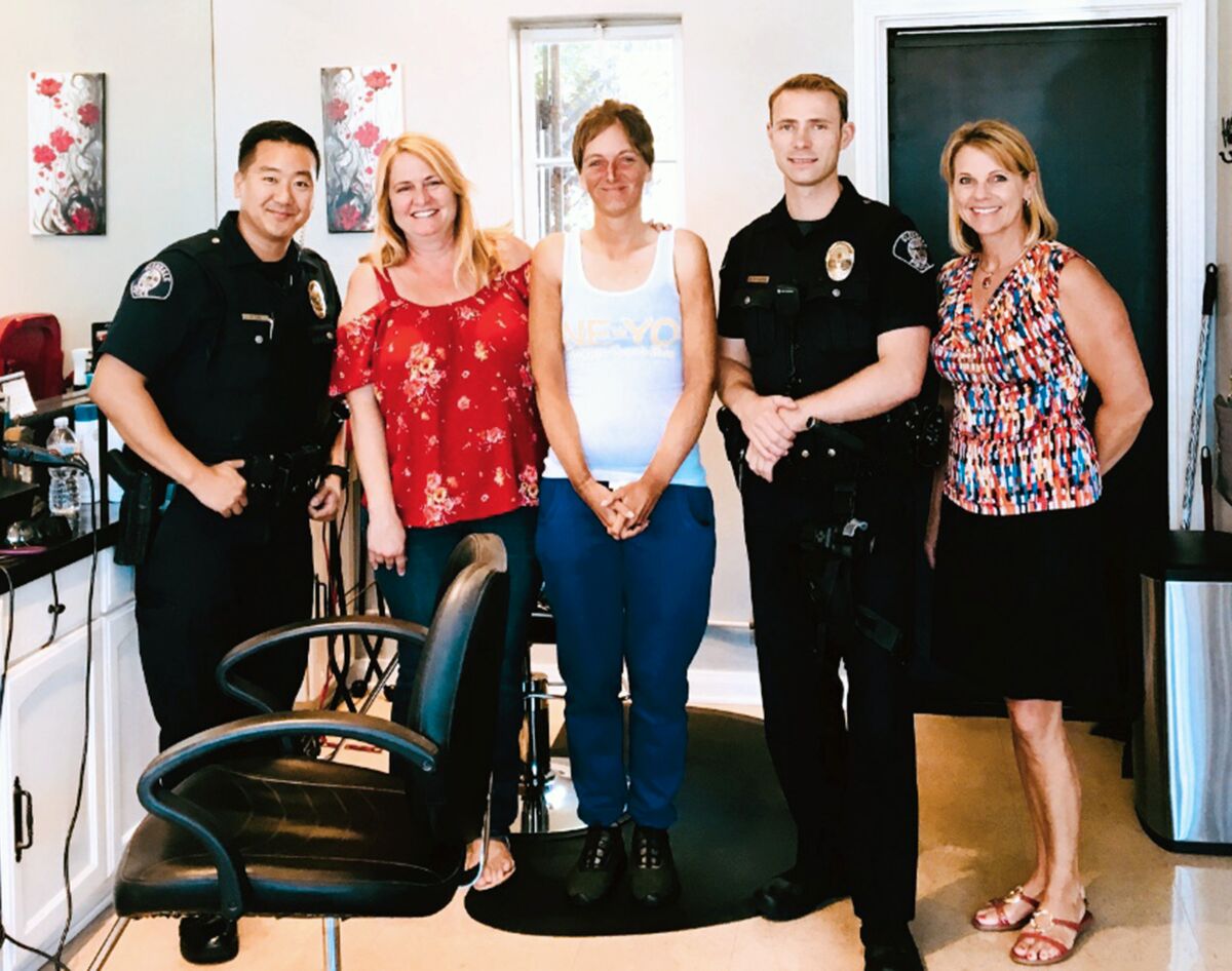 From left, Officer Daniel Lee, Thairapy owner Cindy Burns, Karol-Ann Roberts, Officer Mark Newborg and Glendale police media relations coordinator Tahnee Lightfoot pose for a photo after Roberts was given a makeover by Burns. 