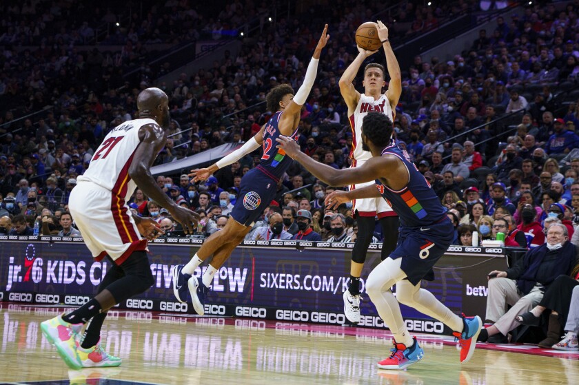 Miami Heat's Duncan Robinson, center rear, puts up the shot with Philadelphia 76ers' Matisse Thybulle, center left, defending as Joel Embiid, right, looks on during the first half of an NBA basketball game, Wednesday, Dec. 15, 2021, in Philadelphia. (AP Photo/Chris Szagola)