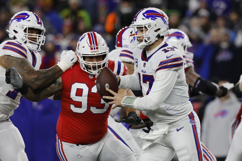 Buffalo Bills quarterback Josh Allen (17) runs while pressured by New England Patriots defensive end Lawrence Guy (93) during the first half of an NFL football game, Thursday, Dec. 1, 2022, in Foxborough, Mass. (AP Photo/Michael Dwyer)