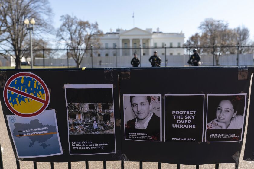 FILE - Signs and pictures of those killed, including journalist Brent Renaud, are displayed on a fence during a protest against Russia's invasion of Ukraine in Lafayette Park near the White House, Sunday, March 13, 2022, in Washington. The International Federation of Journalists says 67 journalists and media staff have been killed around the world so far in 2022, up from 47 last year. (AP Photo/Alex Brandon, File)
