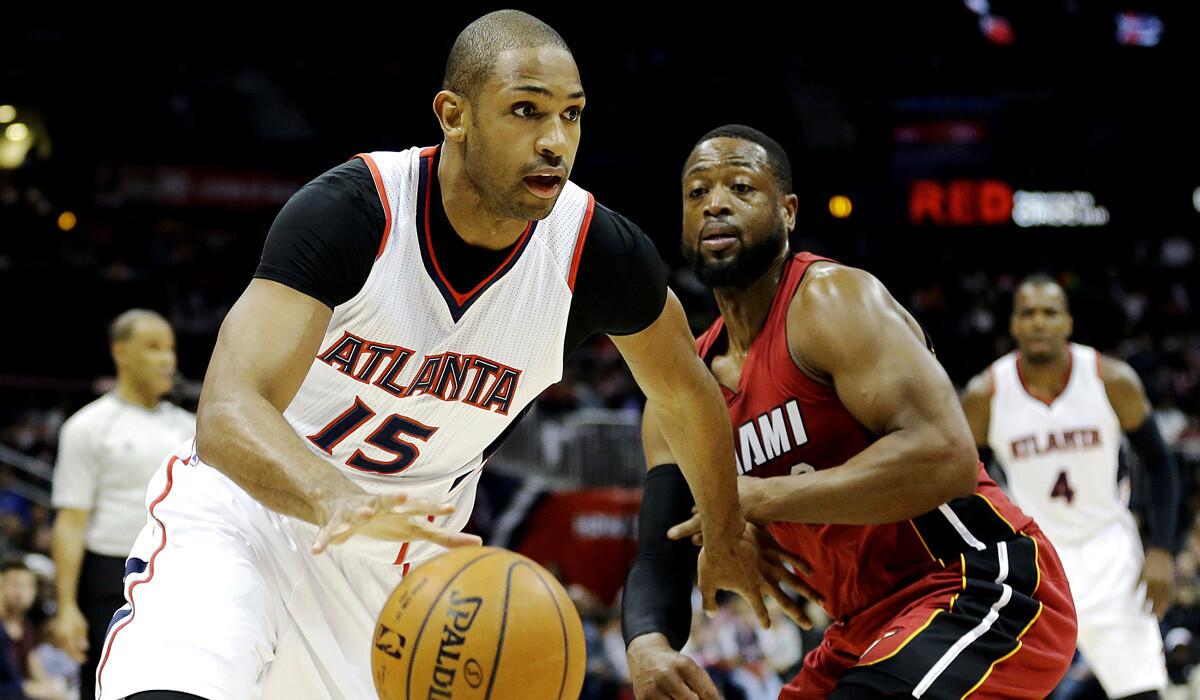 Atlanta's Al Horford, left, dribbles against Miami's Dwyane Wade during the Hawks', 99-86, win over the Heat on Friday.