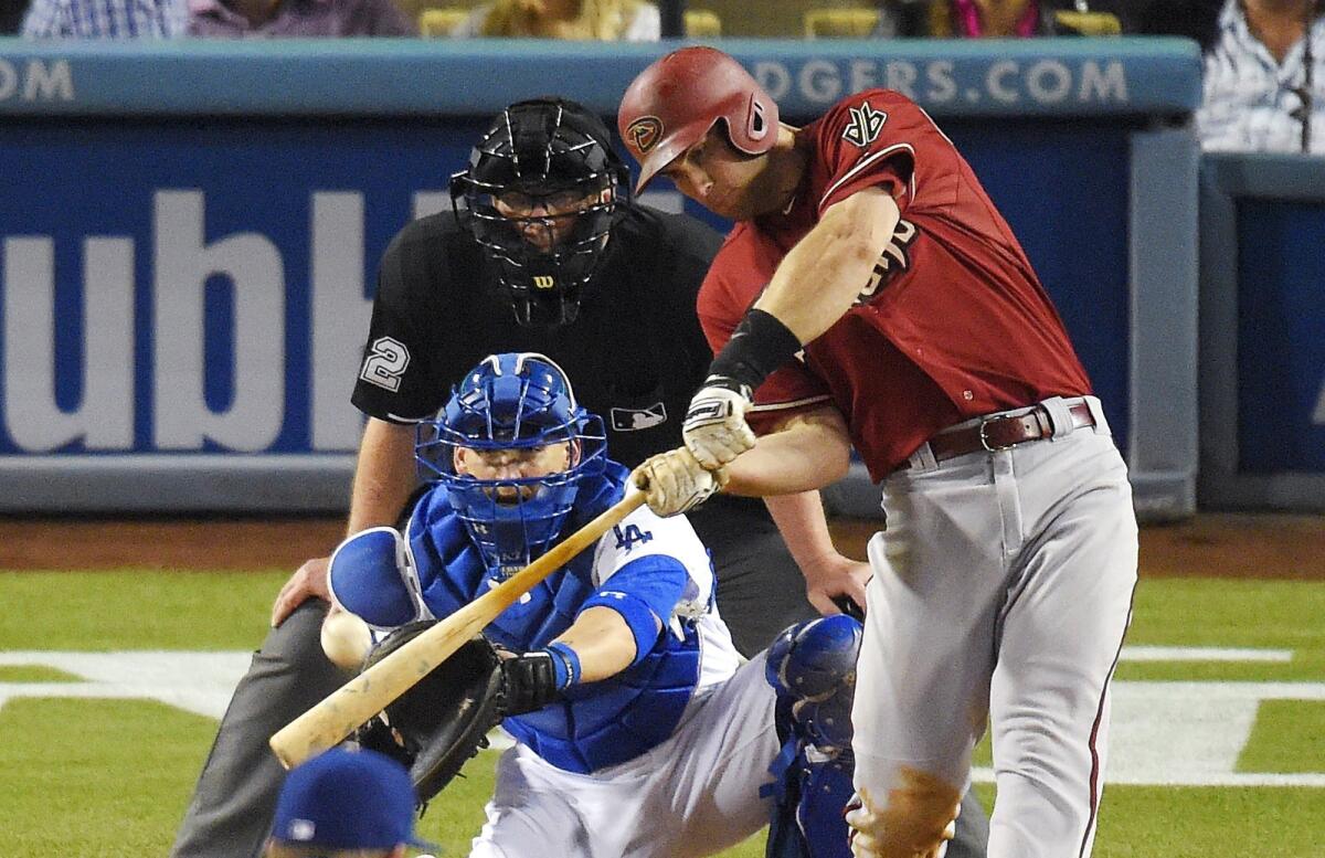 Arizona's Paul Goldschmidt hits a two-run home run in front of Dodgers catcher Yasmani Grandal and umpire Gerry Davis on Wednesday night.