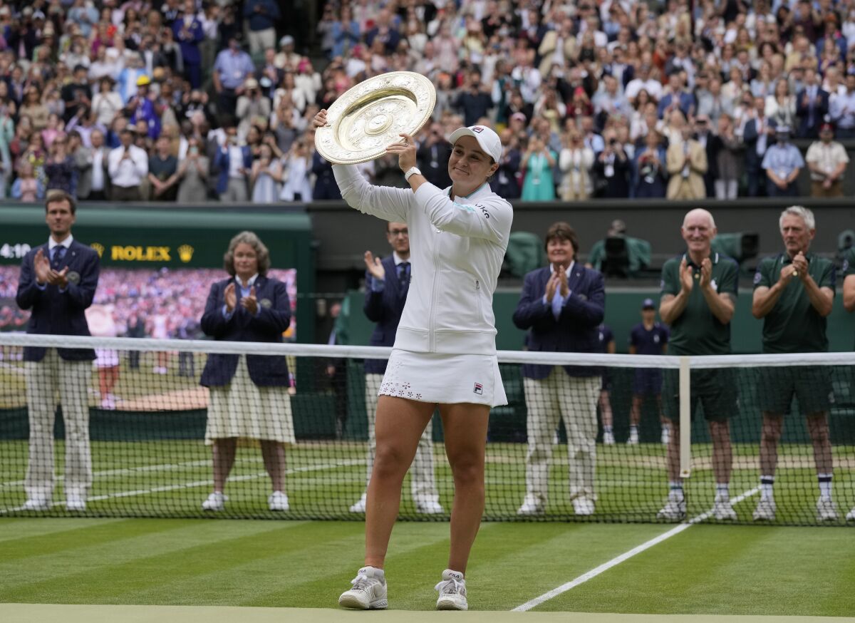 Australia's Ashleigh Barty poses with the trophy for the media after winning the women's singles final, defeating the Czech Republic's Karolina Pliskova on day twelve of the Wimbledon Tennis Championships in London, Saturday, July 10, 2021. (AP Photo/Kirsty Wigglesworth)