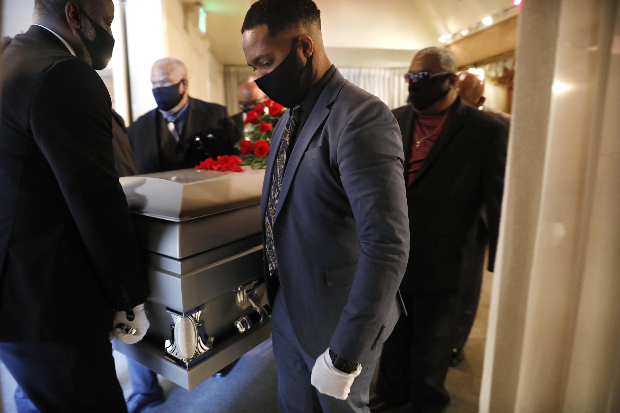 Pallbearers including Nick Jackson, center, carry Charles Jackson's coffin.
