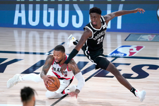 Portland's Damian Lillard chases the ball in front of Brooklyn's Caris LeVert during the teams' game Aug. 13 in Lake Buena Vista, Fla.