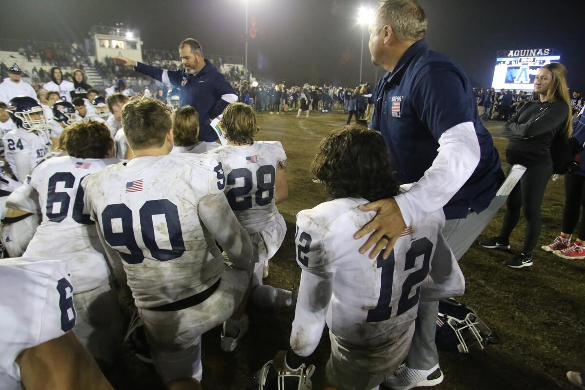 Newport Harbor head coach Peter Lofthouse, left, encourages his team after the loss against Aquinas on Friday night.