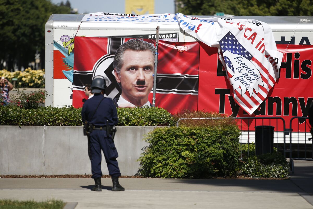 A protest sign against  Gov. Gavin Newsom on the side of a truck outside the state Capitol  