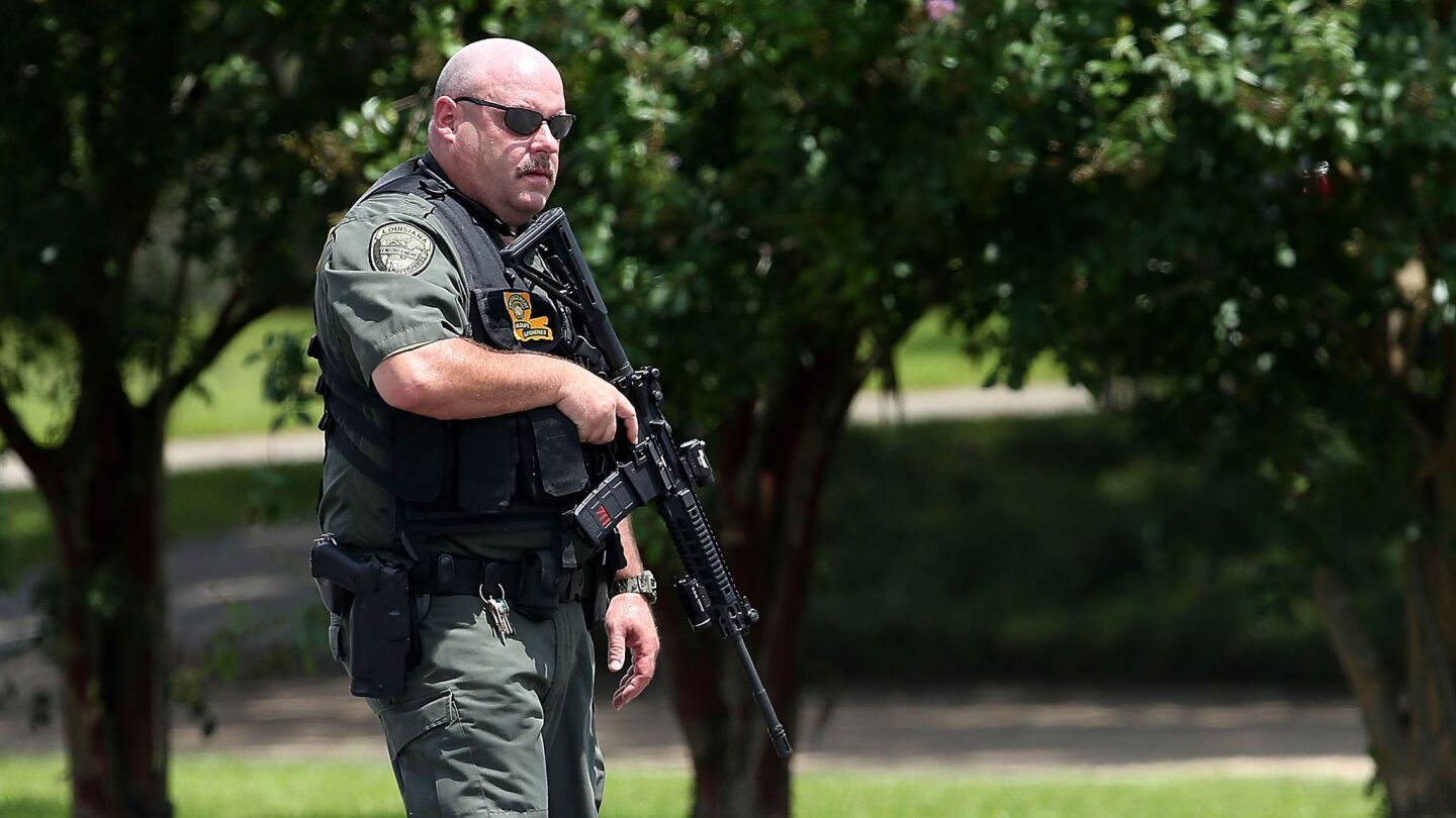 A law enforcement officer patrols Airline Highway in Baton Rouge, La., after three officers were shot to death Sunday morning.