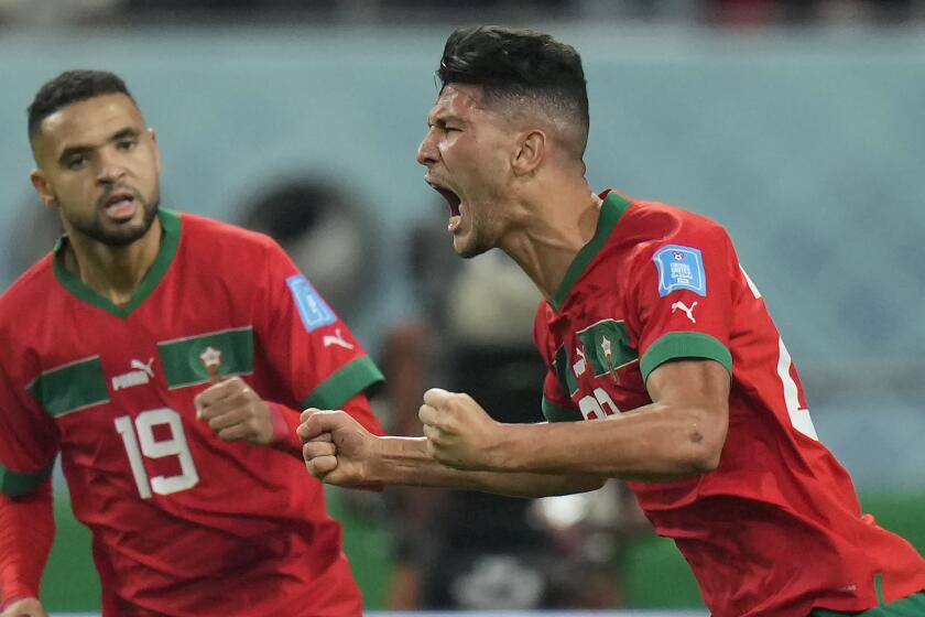 Morocco's Achraf Dari, right, celebrates after scoring his side's first goal.