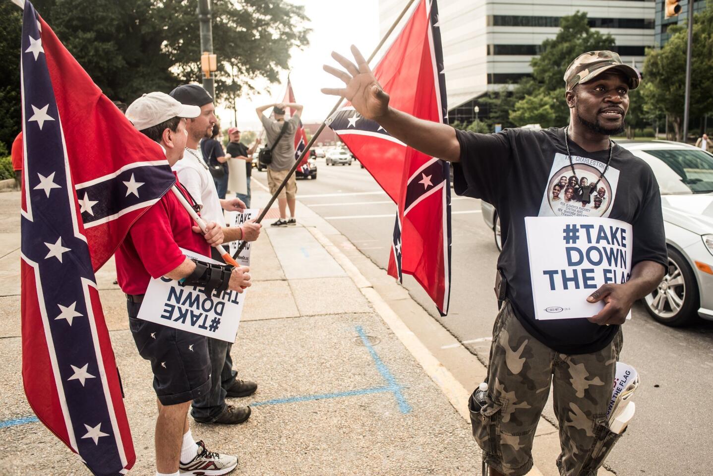 Calvin Bennett, right, talks with Confederate flag supporters outside the Statehouse in Columbia, S.C.