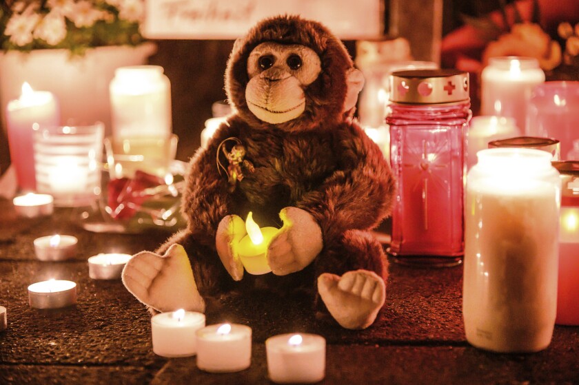This Wednesday, Jan. 1, 2020, file photo, a toy ape is placed between candles at the entrance of the Zoo in Krefeld, Germany. Authorities said rescuers found a gorilla and a female orangutan still alive amid the charred remains of the primate house after the fire on the new year morning. Vets were able to euthanize the orangutan but struggled to do so with the gorilla. After getting permission from a senior officer, a 34-year-old policeman killed the gorilla with shots from his submachine gun. ( Alexander Forstreuter/dpa via AP)