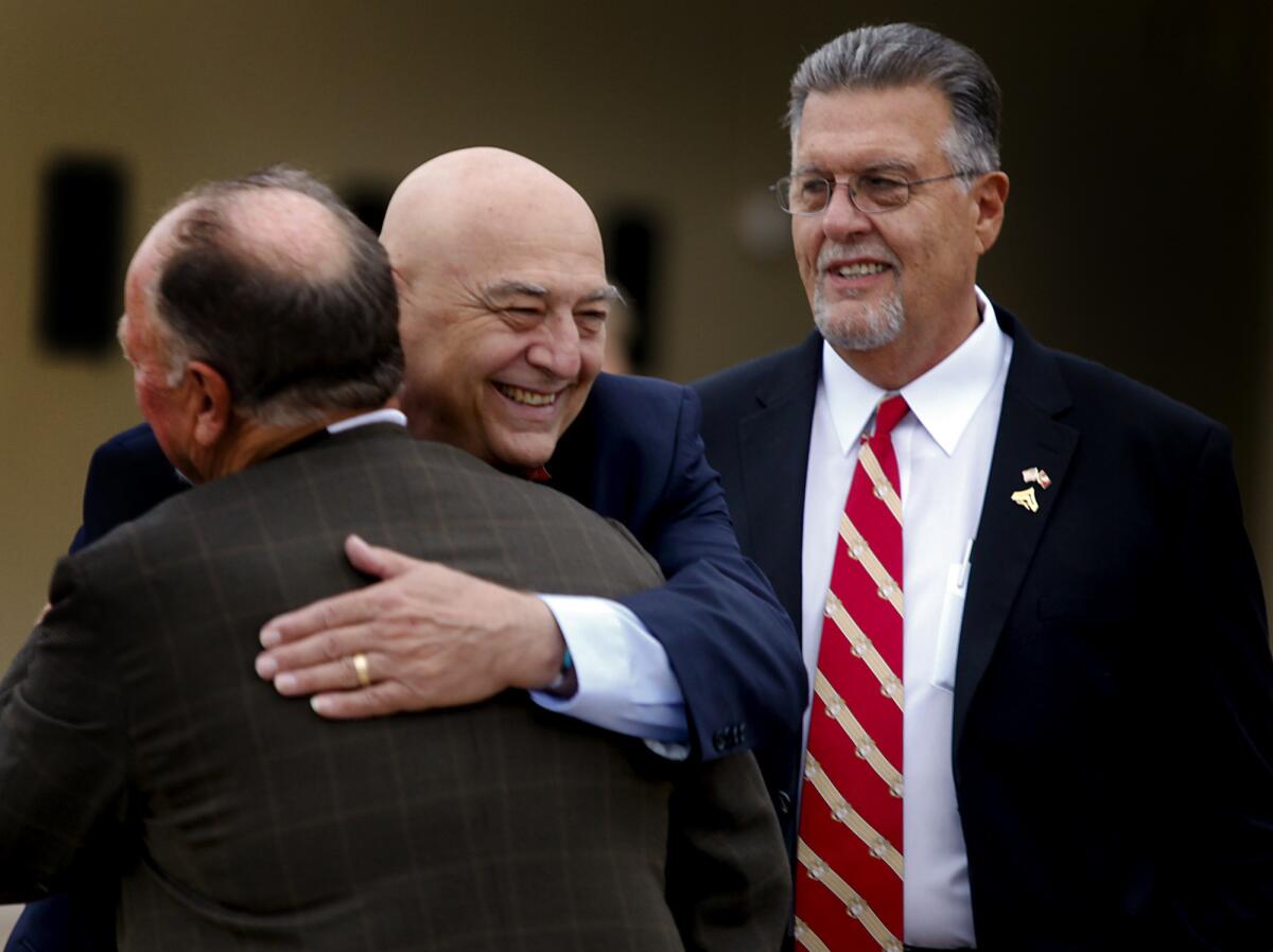 Marines Joseph Cordileone, center, and Robert Moffatt, right, exchange hugs with fellow veterans at a ceremony in San Diego. They received medals for bravery in combat during the first battle of Khe Sanh, Vietnam, in 1967.