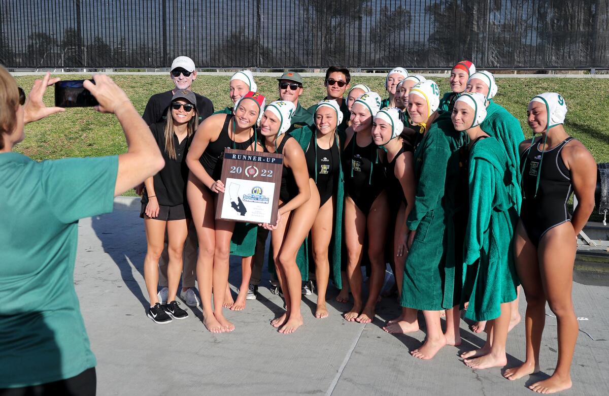 The Edison girls' water polo team poses for pictures with its runner-up plaque after losing 5-3 to Yucaipa.  