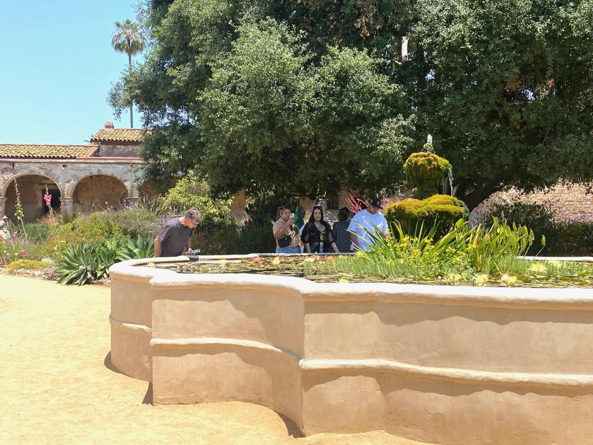 Guests visit an outdoor area at Mission San Juan Capistrano.