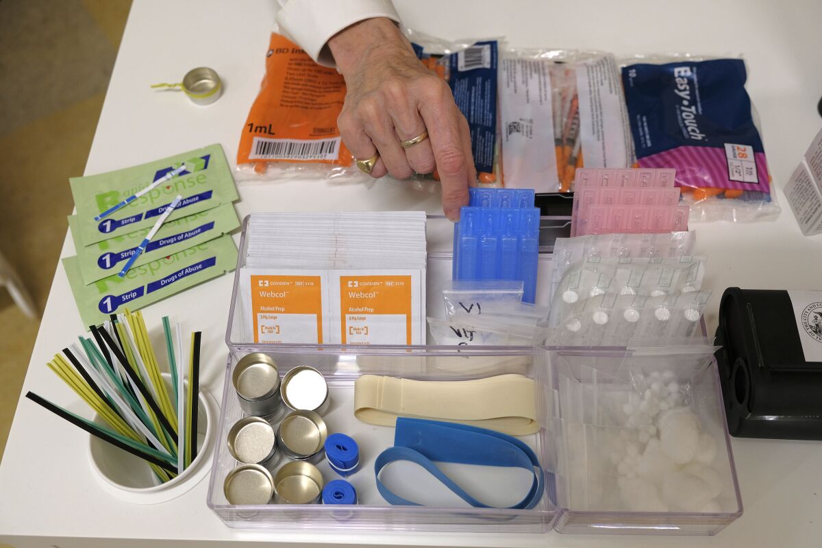 File - Supplies are shown on a desk at Safer Inside, a realistic model of a safe injection site in San Francisco, Aug. 29, 2018. The Justice Department is signaling it might be open to allowing so-called safe injection sites, or safe havens for people to use heroin and other narcotics with protections against fatal overdoses. The department's stance comes a year after federal prosecutors won a major court ruling that found the sites would violate federal law. The Justice Department tells The Associated Press it is talking to regulators about “appropriate guardrails” for the sites. (AP Photo/Eric Risberg, File)
