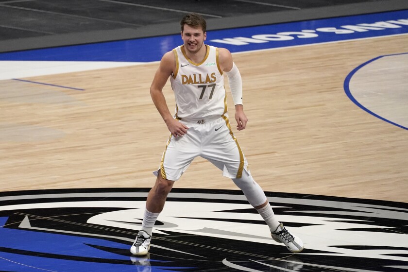 Dallas Mavericks' Luka Doncic smiles at the bench after sinking a long 3-point basket during the second half of the team's NBA basketball game against the New Orleans Pelicans in Dallas, Friday, Feb. 12, 2021. (AP Photo/Tony Gutierrez)