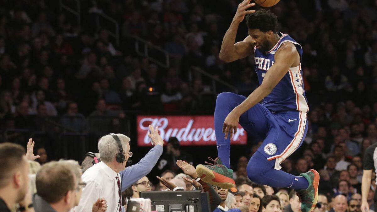 Philadelphia 76ers' Joel Embiid leaps into the stands while chasing a loose ball Feb. 13 in New York.