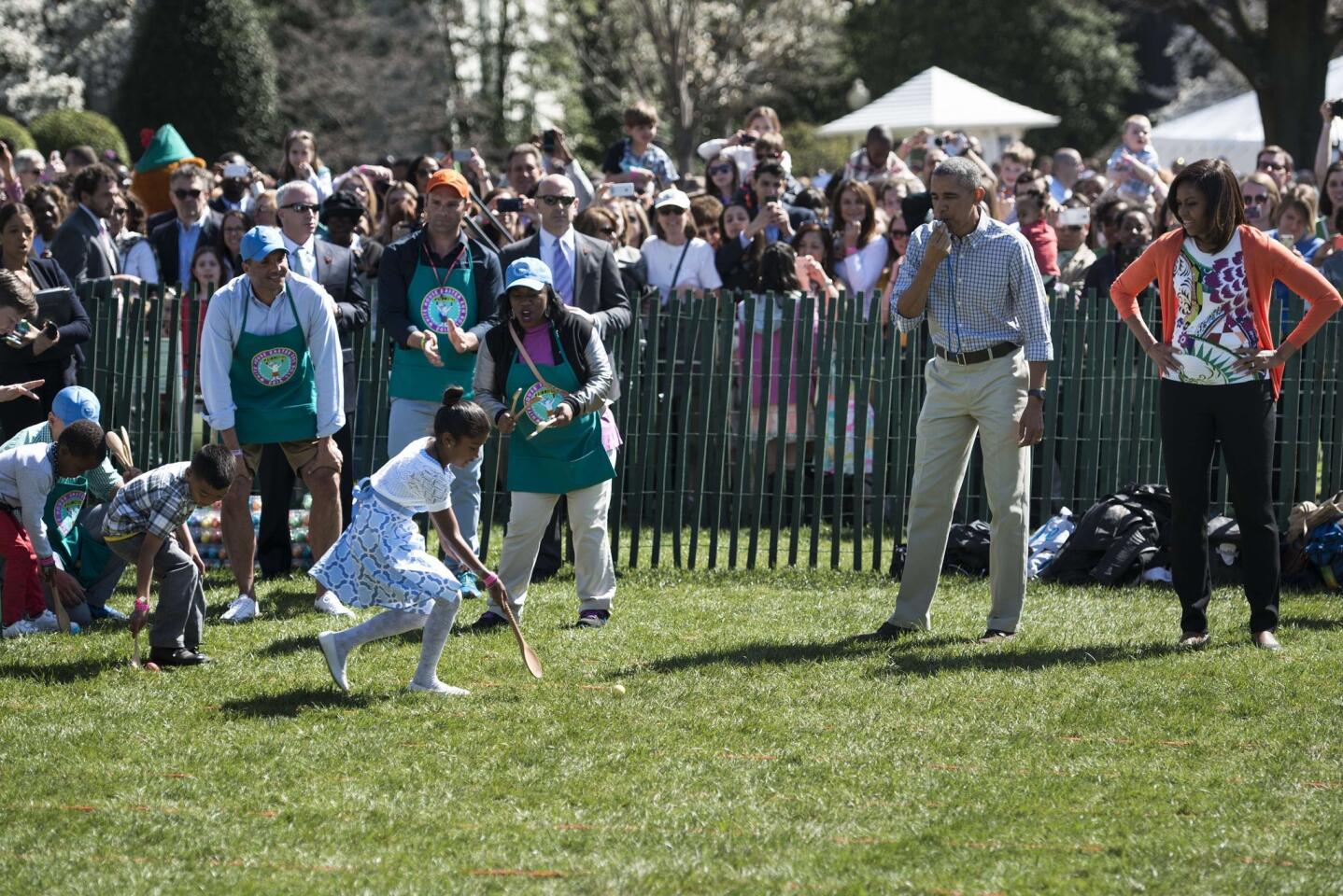 President Barack Obama and first lady Michelle Obama watch children during the annual Easter Egg Roll at the White House on April 6, 2015.