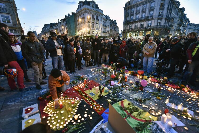 People bring flowers and candles to mourn at the Place de la Bourse in the center of Brussels after bombs exploded at the city's airport and one of the metro stations Tuesday. More than 34 people died in the blasts.