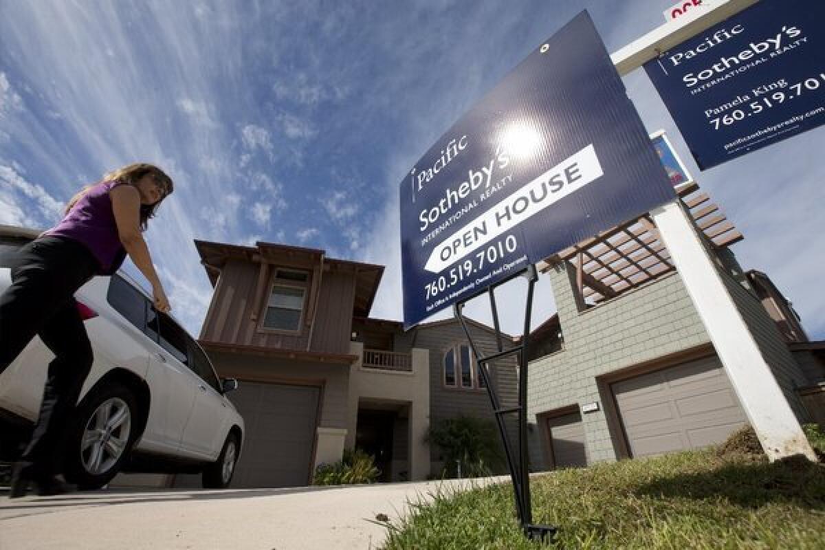 A woman arrives at a viewing for brokers of a home just put on the market in Leucadia, Calif.