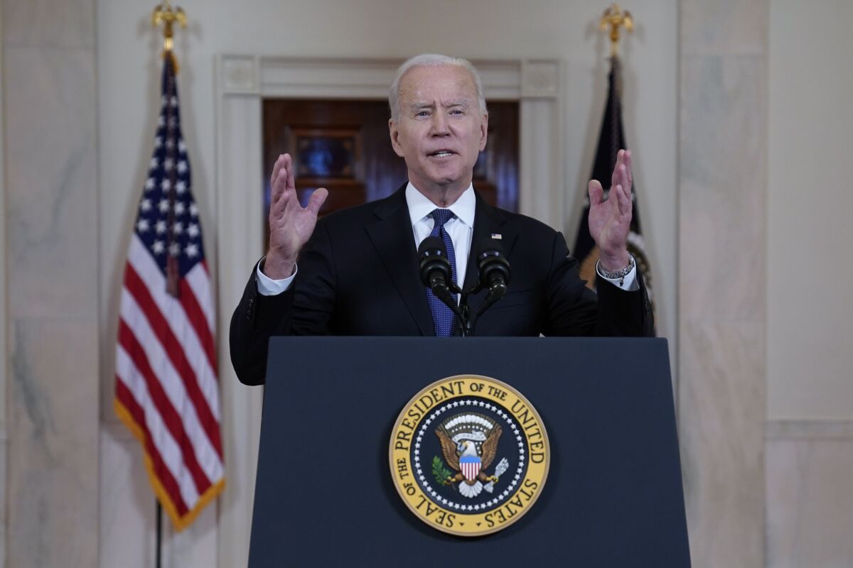 Biden speaks into a microphone at a podium with the presidential seal
