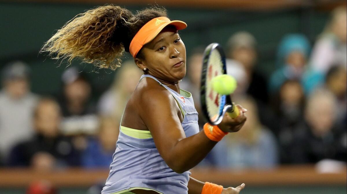 Naomi Osaka returns a shot to Simona Halep during their semifinal match Friday night.