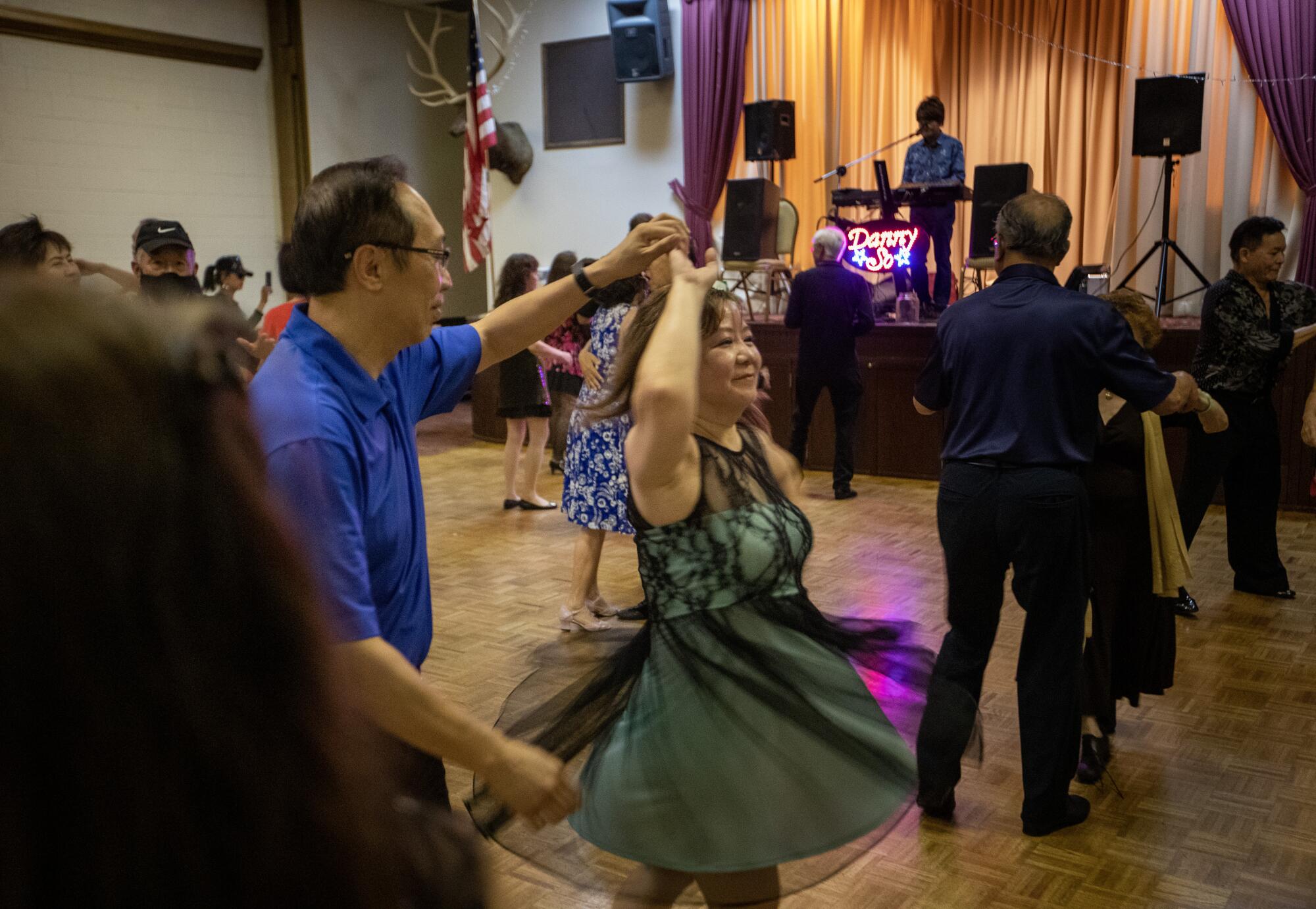 A man twirls a woman on the dance floor.