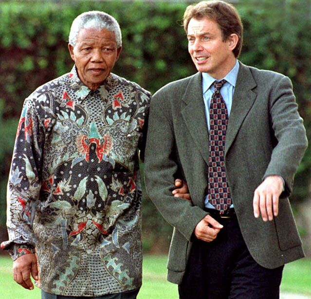 South African President Nelson Mandela takes the arm of British Prime Minister Tony Blair as they chat while strolling on the grounds of the Royal and Ancient St. Andrews Golf Course during a break in the Commonwealth Heads of Government Meeting on Oct. 26, 1997.