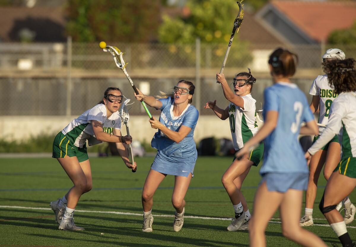Corona del Mar's Abby Grace takes a shot under pressure from Edison's Katie Wright, left, and Katie Baker on Tuesday.