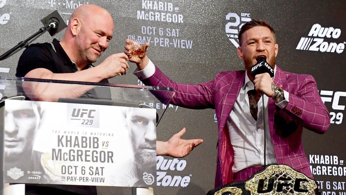 Conor McGregor, right, shares his Irish Whiskey with UFC president Dana White during a news conference on Sept. 20.