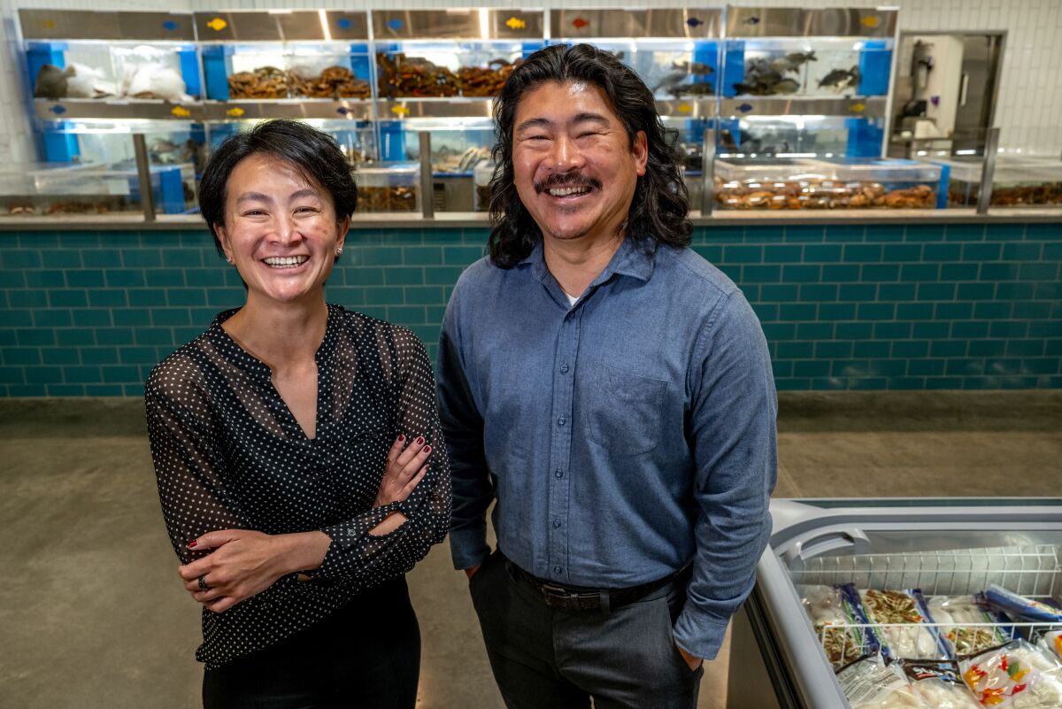 A woman and a man stand smiling in a grocery store.